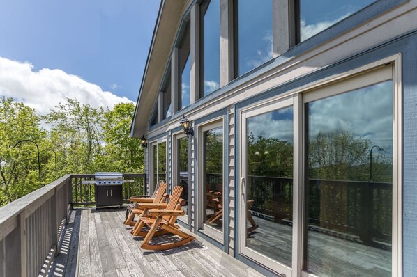 Eine überdachte Terrasse mit Sitzgelegenheiten und einem Grill.