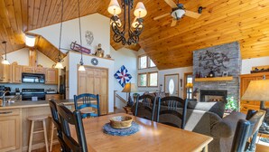 Un'ampia cucina con mobili in legno, un'isola centrale e un'area pranzo con tavolo e sedie in legno.