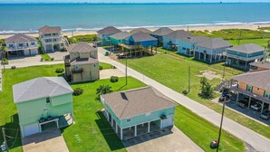 Zona residencial costera con casas, una playa y cielo despejado.