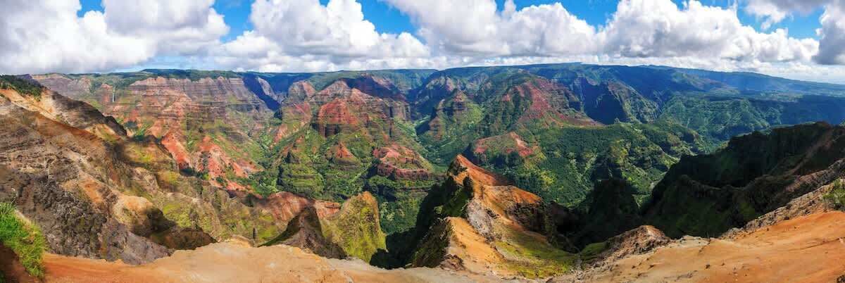 Une vue panoramique d’un canyon aux reliefs accidentés et à la végétation luxuriante.