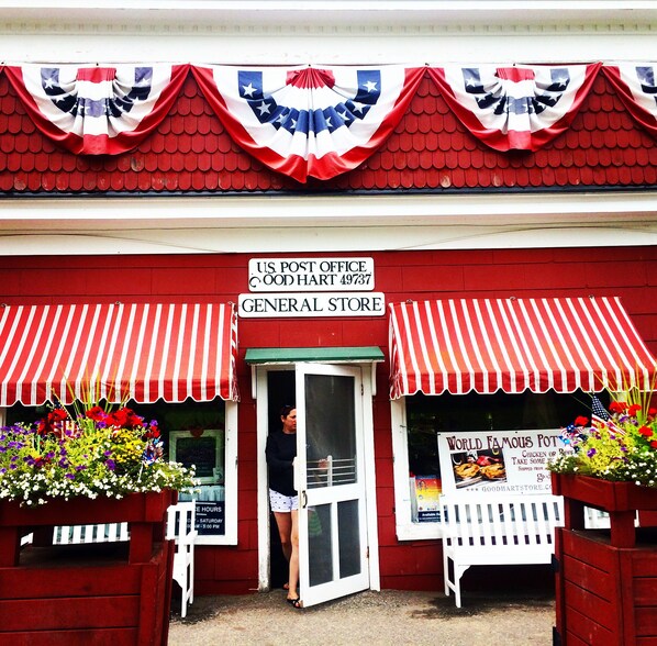 A red storefront with a U.S. Post Office sign, a general store, and a World Famous Pot sign.
