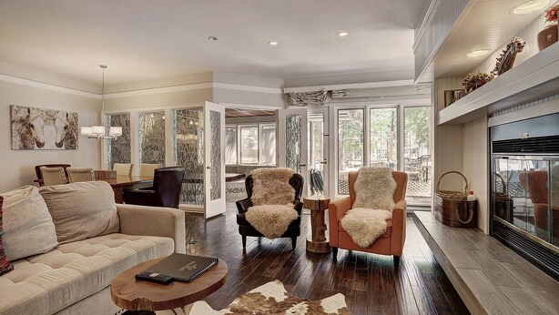 A spacious living room with a fireplace, a dining area, and a large window providing natural light. - Stunning Ski-In Ski-Out Condo/Private Hot Tub/Recently Updated (Dillon)