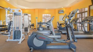 A gym with various exercise equipment including treadmills, elliptical machines, and weight machines.