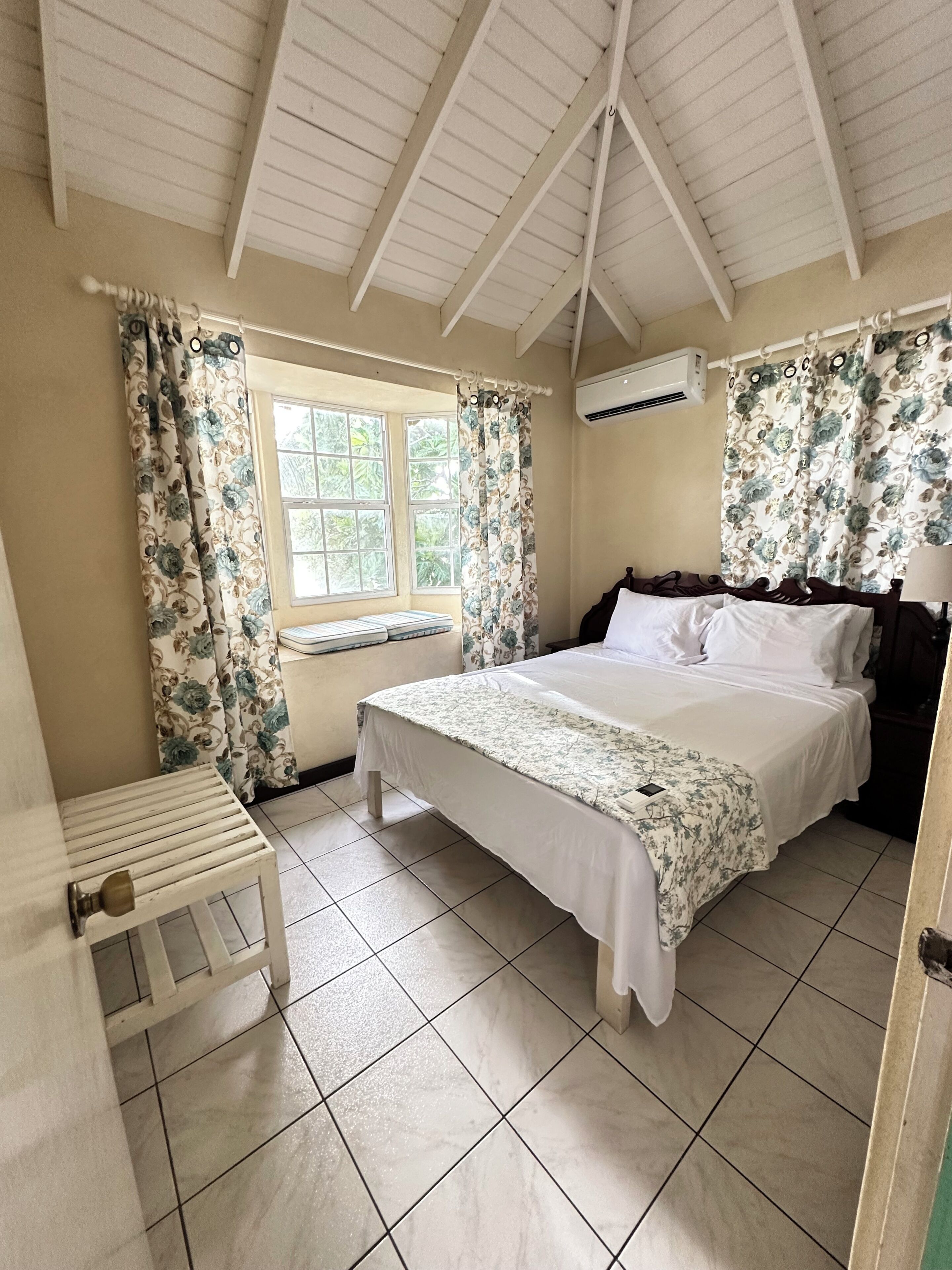A bedroom with a bed, a window, and a ceiling fan.