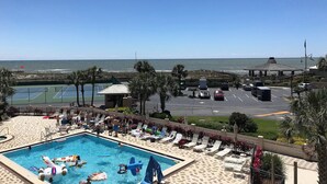 A pool area with lounge chairs and a view of the ocean. - 🌅 Islander #307 – Sunrise Coffee & Front-Row Beach Action! 🌊🏄‍♂️ (Destin)