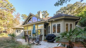 A house with a patio, outdoor furniture, and a grill.