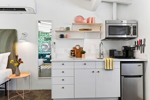 Uma cozinha compacta equipada com micro-ondas, torradeira e frigorífico.