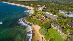 Vista aérea de una propiedad costera con playa, piscina y campo de golf.