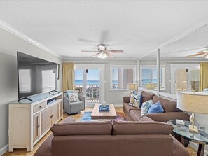 Relax in this stylish living room with a large flat-screen TV, comfortable sofa, and glass coffee table.