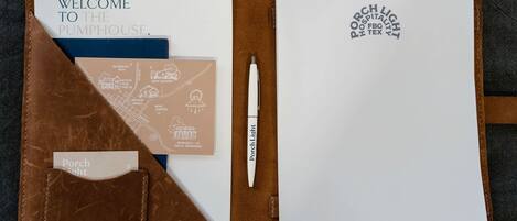 Un cuaderno de cuero con una nota de bienvenida, un mapa y una pluma.