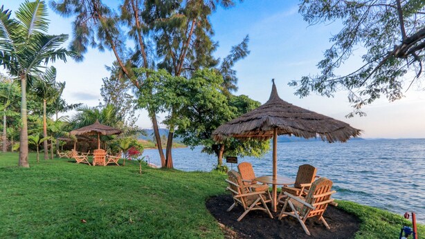 A serene lakeside setting with thatched umbrellas and wicker chairs. - Hakuna Matata Lodge (Gisenyi)