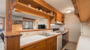 Una cocina con armarios de madera, un lavamanos, una estufa y un microondas.
