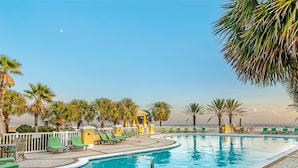 A pool area with lounge chairs and palm trees. - 304W ~ Relax with beautiful Gulf views in this 3BR/3BA center condo (Gulf Shores)