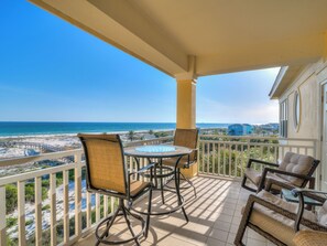 A balcony with a view of the beach and ocean, furnished with wicker chairs and a glass table. - 304W ~ Relax with beautiful Gulf views in this 3BR/3BA center condo (Gulf Shores)