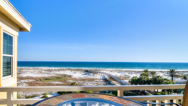 A balcony with a glass table and chairs overlooking a beach with a wooden walkway and palm trees. - 304W ~ Relax with beautiful Gulf views in this 3BR/3BA center condo (Gulf Shores)