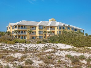 A multi-story hotel with balconies, located on a sandy beach with vegetation. - 304W ~ Relax with beautiful Gulf views in this 3BR/3BA center condo (Gulf Shores)