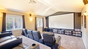 A home theater room with a large screen, multiple seating areas, and a carpeted floor. - Amazing Lake View, Dogs Ok, UNIVERSAL EV CHARGER, Hot Tub, Kayaks (Lake) (Ocean Park)