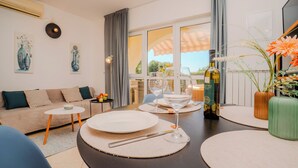 Un salon moderne avec un canapé, une table basse et une table à manger dressée pour le repas.