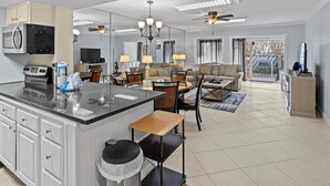 Un grand espace de vie comprenant une cuisine, une table à manger et un coin salon.