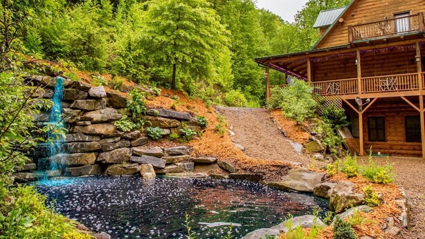 A wooden cabin with a stone waterfall and pond. - 7 Bedroom 5.5 Bath Stunning Luxury Log, Reunions & Weddings Welcomed (Maggie Valley)