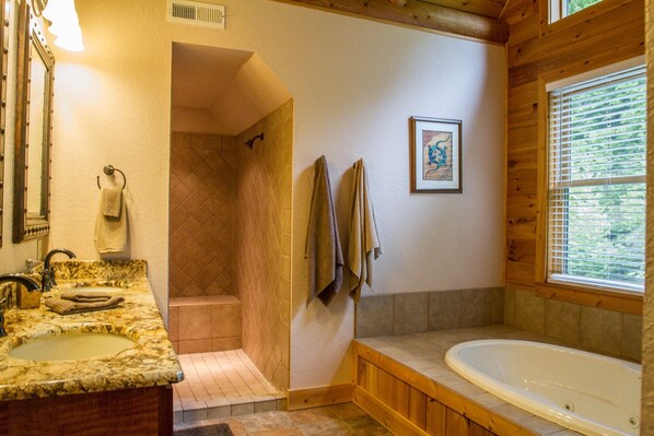 A bathroom with a marble sink, a bathtub, a shower, and wooden walls. - 7 Bedroom 5.5 Bath Stunning Luxury Log, Reunions & Weddings Welcomed (Maggie Valley)