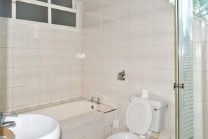 A bathroom with a bathtub, toilet, and sink. - Westwood Hotel Nyeri (Nyeri)