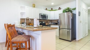 A kitchen with white cabinets, a stainless steel refrigerator, a microwave, and a sink. - *Premier Host* Sonoran Sun W-609  Sun & Fun Sanctuary Spacious Oceanfront (Puerto Penasco)
