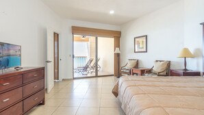 A hotel room with a bed, a TV, a desk, chairs, a lamp, and a view of a pool through a sliding door. - *Premier Host* Sonoran Sun W-609  Sun & Fun Sanctuary Spacious Oceanfront (Puerto Penasco)