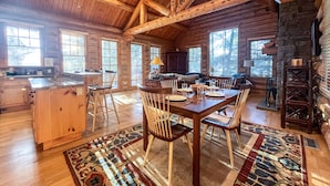 A spacious log cabin with a large dining area, kitchen, and multiple windows. - JHRL - Beautiful Single-Family Granite Ridge Cabin #7590, Hot Tub (Teton Village)