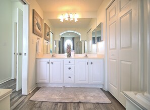 A spacious bathroom with a large vanity, double sinks, and a mirror above the countertop.