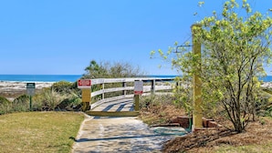 A wooden pathway leading to a beach with a warning sign about dune rebuilding and a sign advising to leave dog poop. - 105W ~ 2BR/2BA condo with Beachfront View (Gulf Shores)