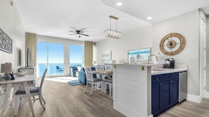 Una cocina moderna con comedor, ventanas amplias y vista al océano.