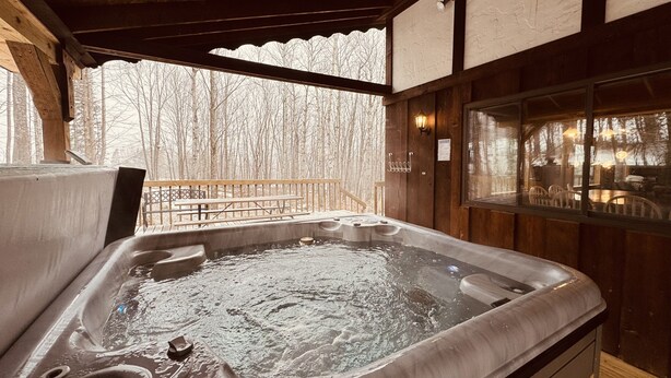 A hot tub with a wooden deck and a view of trees. - Trailside Home on Alpen Trail with Hot Tub & Allows Dogs (Bessemer)