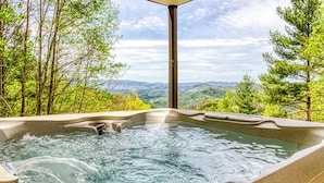 A hot tub with a view of a mountainous landscape.