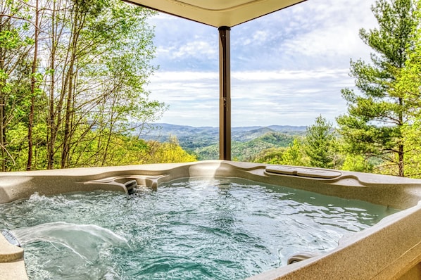 A hot tub with a view of a mountainous landscape.