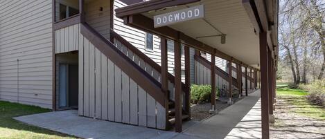 A building with a covered porch, a staircase, and a sign reading "DOGWOOD".