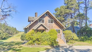 A two-story house with a gabled roof, a front porch, and a gravel driveway. - Pets OK, OCEAN VIEW, Beach Path, HOT TUB, Large Yard (FirstM) (Ocean Park)