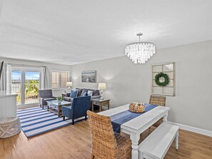 Relax in this stylish living area with a large dining table, comfortable sofa, and chandelier.
