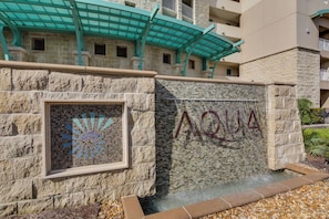 A stone wall with a mosaic window and the word "AQUA" on it. - 2306 - Nautical Style Couples Retreat (Panama City Beach)
