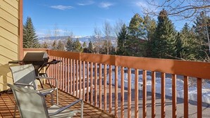 Ein Balkon mit Blick auf schneebedeckte Berge und Bäume.