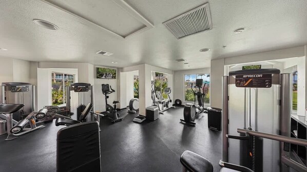 A modern gym with various exercise equipment, including treadmills, stationary bikes, and weight machines.