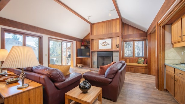 A spacious living area with leather sofas, a wooden coffee table, and a fireplace. - JHRL - Teewinot D4, Great Slopeside Location (Teton Village)