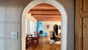 Un coin repas avec des chaises et une table en bois, un mur d’accent bleu et une cheminée.