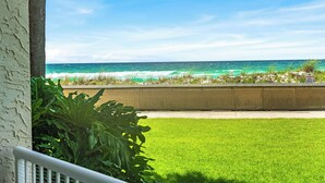 A view of a grassy area with a concrete barrier and a sign, leading to the ocean. - 121- Ground floor unit-steps to the wonderful beach, W/D in unit,FREE Bch Svc (Destin)