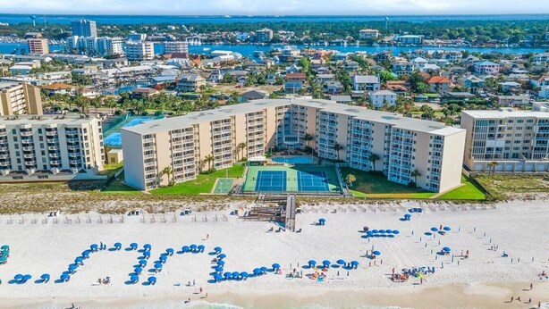 A resort with multiple buildings, a pool, and a beach with umbrellas. - 121- Ground floor unit-steps to the wonderful beach, W/D in unit,FREE Bch Svc (Destin)