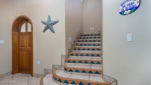 A staircase with a curved design, a wooden door, and a starfish decoration on the wall.