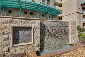 A stone wall with a mosaic window and the word "AQUA" on it.