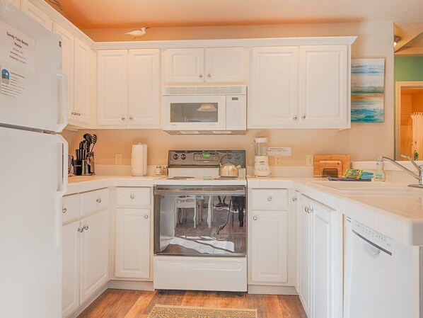 A kitchen with white cabinets, a microwave, an oven, and a dishwasher.