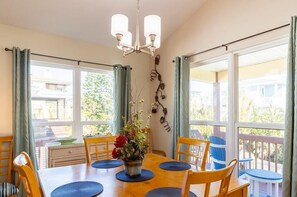 Enjoy meals in this beautifully appointed dining area with a table for four, elegant chandelier, and stunning views of the outdoors.