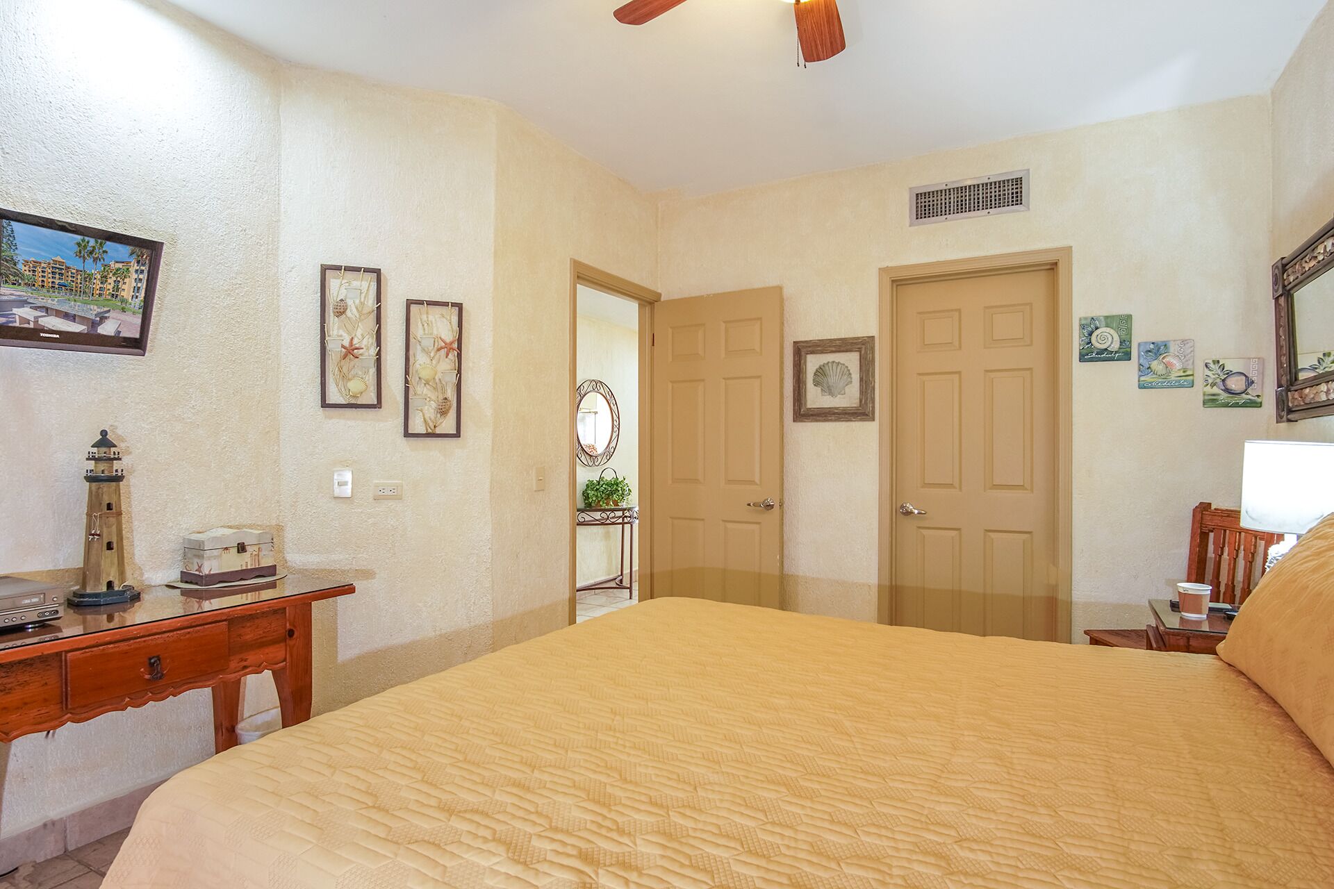 Un dormitorio con una cama grande, un escritorio con una radio y una puerta que da a otra habitación.